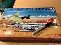 Box and two painted model aircraft illustrating the McAir F-4C/J Phantom II aircraft model kit, 1/72 scale.
