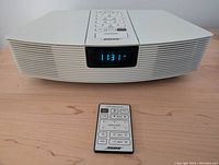 Front view of Wave Radio and remote on tabletop showing digital clock display at 11:31 and front grille