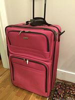 Full front view of red Tracker suitcase standing upright with extended handle visible.