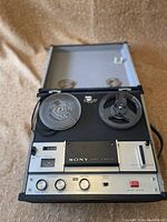 Front view of vintage Sony Stereo 8 Maestro reel to reel tape recorder with tape reels on spindles and controls visible.