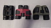 Top view of three binoculars showing size and design difference.
