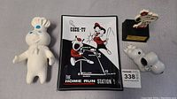 Photo showing the 7-inch rubber Pillsbury Doughboy toy, Snoopy trophy, ceramic Snoopy figure and glass plate with cartoon figures
