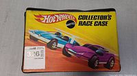 Top view of closed Hot Wheels Collector's Race Case with graphic of two stylized racing cars and Mattel logo