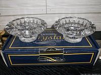 Two round clear crystal candlestick holders displayed on a box labeled 'Genuine Crystal Candleholder Set'