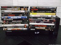 Stack of 24 assorted DVDs showing various movie titles in cases.