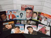 Photo showing multiple Elvis Presley vinyl record covers with color and black-and-white images.
