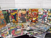 Multiple comic books displayed with colorful superhero covers including The Comet, Black Panther, and others, showing condition and variety in the collection.