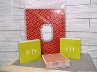 Four Stella and Dot jewelry boxes, unopened and new, including two yellow-green S D branded small boxes, one orange patterned box with Stella and Dot logo, and one peach colored box
