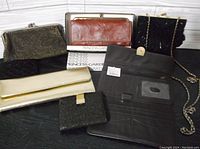 Photo showing various wallets and clutches in black, gold, and brown including a furry clutch with chain strap and two mesh wallets.