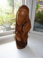 Front view of the wooden bust showing the woman and child figures