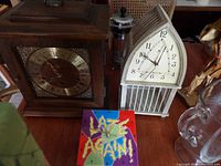 Two clocks pictured on a surface with other miscellaneous items