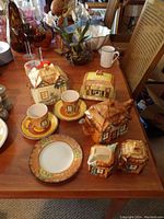 Full view of all ceramic cottage-themed dishware set pieces arranged on table