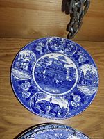 Blue decorative porcelain plate showing multiple historic buildings including Independence Hall in Philadelphia with floral border.