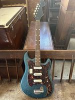 Full front view of electric guitar leaning against bench