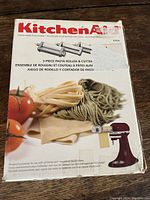 Front of boxed KitchenAid pasta attachment set showing logo, product image and red mixer graphic