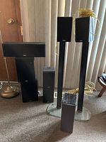 Photo showing various sizes and types of speakers including Energy bookshelf speakers with stands and Yamaha tower speakers.