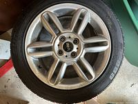 Single tire and rim showing silver alloy rim with Mini logo center cap and tire sidewall visible.