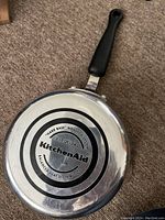 Bottom view showing KitchenAid branding, 2.12 Qt/2.0 L capacity and balanced heat distribution base