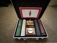 Poker chip set in open metal case showing chips, cards, dice, dealer button