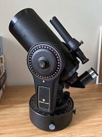 Side view of black Bausch & Lomb telescope showing large circular adjustment dial and eyepiece.