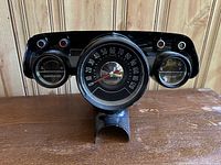 Front view showing the full vintage gauge cluster with speedometer, temperature gauge on left, gasoline gauge on right, and indicator lights on top.