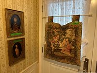 Photo of two framed vintage portrait prints and one hanging vintage French tapestry, lot overview.