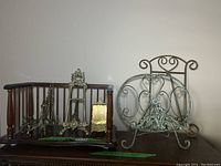 Full view of wooden shelf with brass and metal stands on top arranged for display.