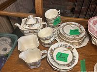 Overall view of the vintage Royal Winton Grimwades china tea set showing teapot, cups, creamer, sugar bowl, and plates arranged on a wooden surface.