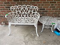 Bench and round side table set against brick wall