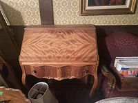 Front view of the desk closed showing the wood grain patterns and curved legs.
