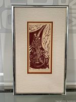 Full view of the framed artwork showing the entire composition and matting within a silver frame.