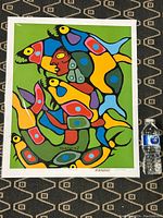 Full view of the colorful Norval Morriseau print next to a water bottle for scale.