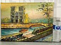 Full view of the framed oil painting showing cathedral, river, boats, dock, and tree.