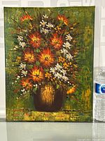 Full view of floral still life oil painting on canvas, showing the arrangement of orange and white flowers in a brown vase against a green background with textured brush strokes.