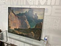 Photo of the full western landscape oil painting on board, showing the complete artwork leaning against a wall with a water bottle nearby for scale.