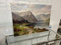 Full view of the signed landscape oil painting featuring mountains, lake, greenery, and sailboats.