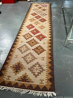 Full view of long narrow kilim rug laid on concrete floor