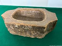 Front angled view of the carved stone bowl showing the interior basin and rough outer texture.