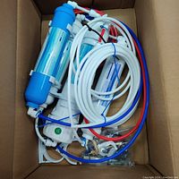 Overview of entire 4 stage RO water filter system showing filter housings, tubing, and fittings.