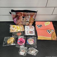 Full overview of majority of items including pins, bracelets, stickers, makeup case, and backpack