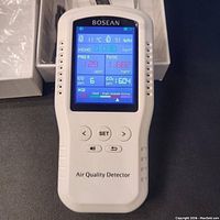Front view of the Bosean air quality detector powered on showing measurement results on the color display.