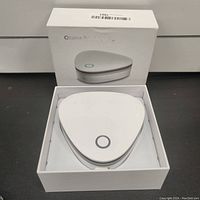 White triangular ozone sterilizer device inside white retail box with product image and name