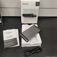 Full kit including SanDisk Professional PRO Multi Card Reader, USB-C cable, user manual, packaging box, and styrofoam insert.