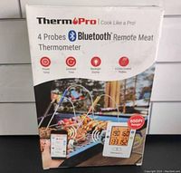 Front view of ThermoPro TP25 box showing a photo of the device with four probes on a grill, Bluetooth logo, and 650ft range indicator.