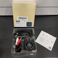 Photo of Bluetooth audio adapter in plastic tray with RCA cables, power cable, and instruction manual, packaging box in background.