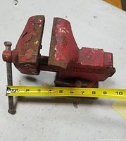 Side-view image of Wilton bench vise showing flaked red paint and a measuring tape indicating size.