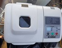 Top view of Breadman bread machine closed, showing control panel with buttons and viewing window on lid.