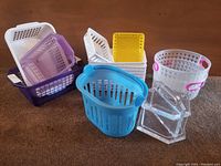 Assorted baskets including purple, white rectangular, yellow, blue, clear containers on carpet