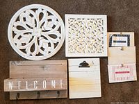 Full set of seven wooden decor pieces on carpet showcasing various shapes and designs, with welcome sign tray and clip frames.