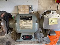 Photo showing entire PowerSonic bench grinder unit with two wheels attached and power switch visible.